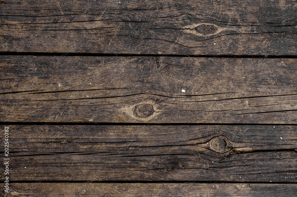 Macrophotography texture background of old dark wooden boards horizontally arranged in a wall Macrophotography texture background of old dark wooden boards horizontally arranged in a wall