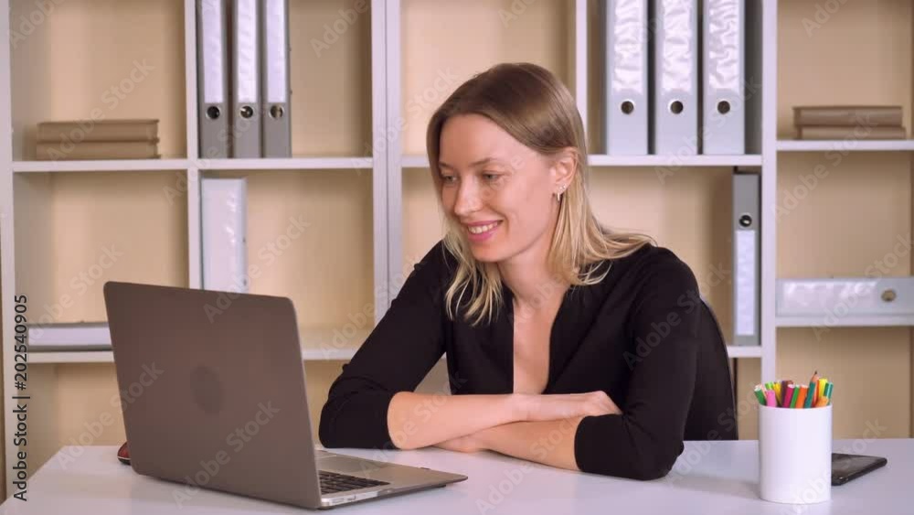busy business woman has video call with family. attractive employer looking on screen laptop talking with happy smile. adult caucasian lady with blonde hair cute smiles