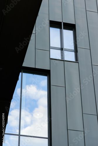windows with reflections of clouds in a modern building, detail of a building