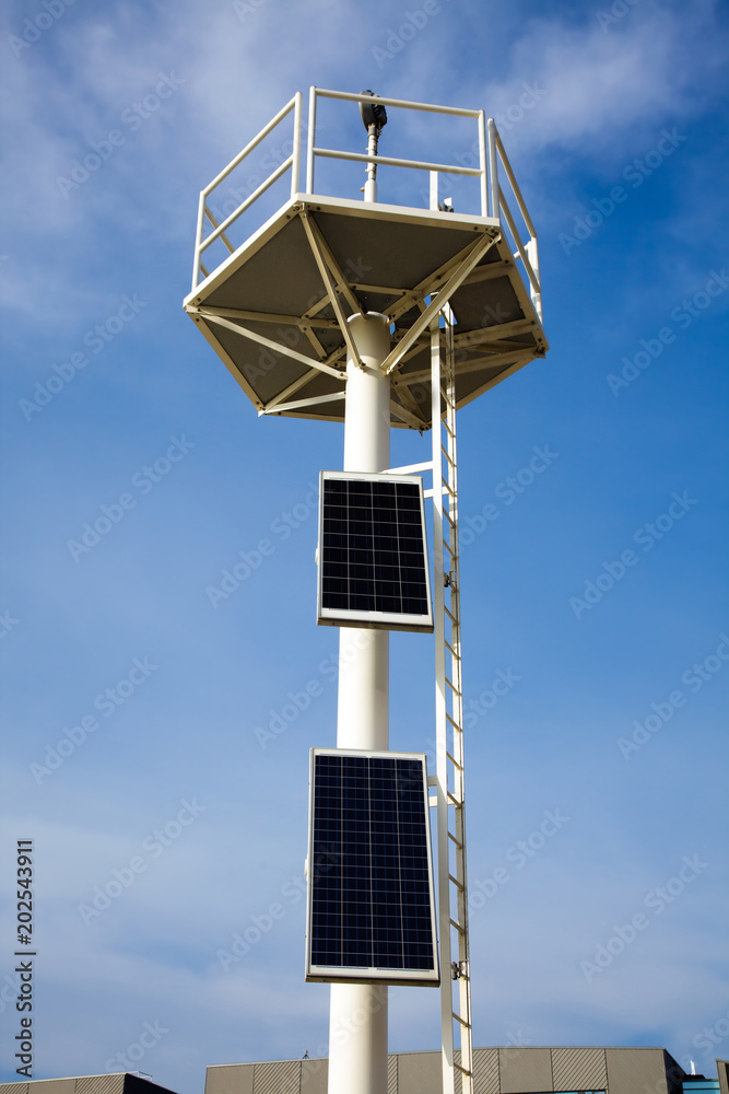 beacon sky solar panels top light house transformation energy blue white sun saving beam two beach port harbor
