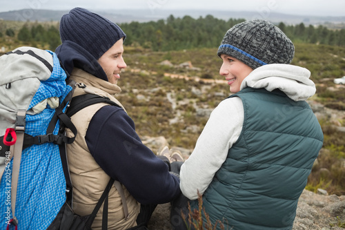 Couple with backpack relaxing while on a hike