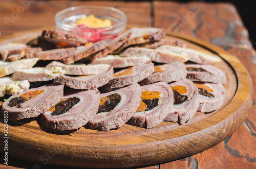 different kinds of meat rolls on a wooden plate. photo