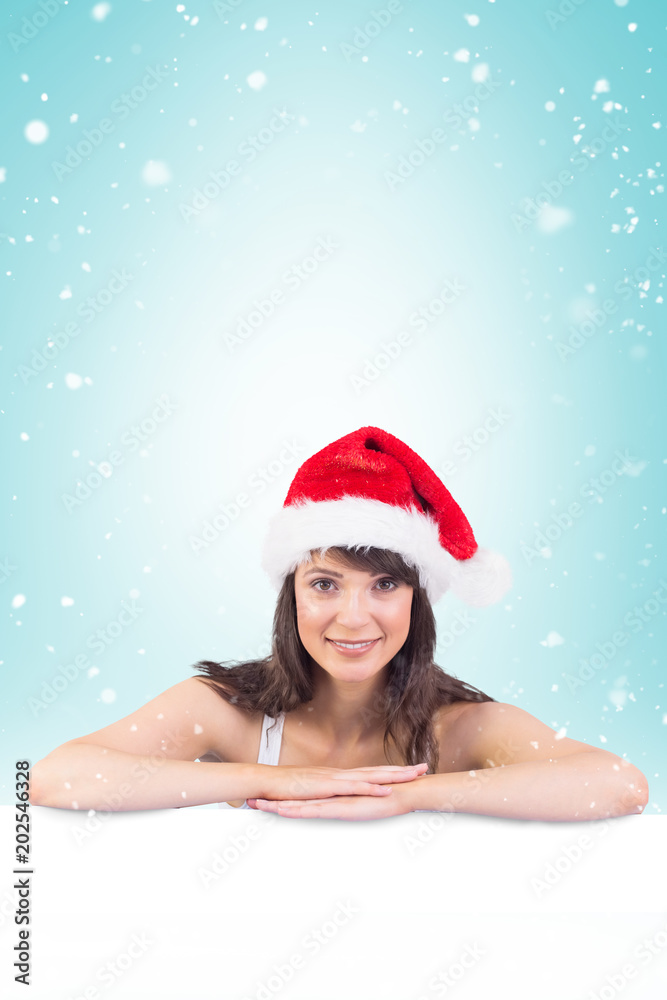 Festive brunette leaning on large poster against blue vignette Festive brunette leaning on large poster against blue vignette