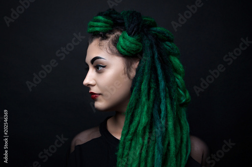 Portrait of a pretty girl with long green dreadlocks.