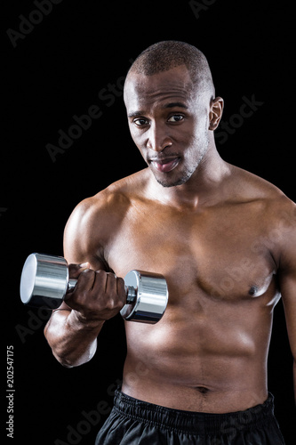 Portrait of athlete exercising with dumbbell