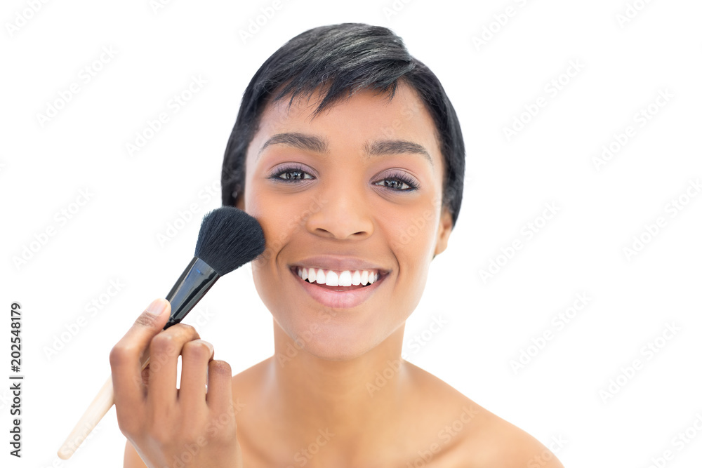 Delighted black haired woman applying powder on her cheeks Delighted black haired woman applying powder on her cheeks