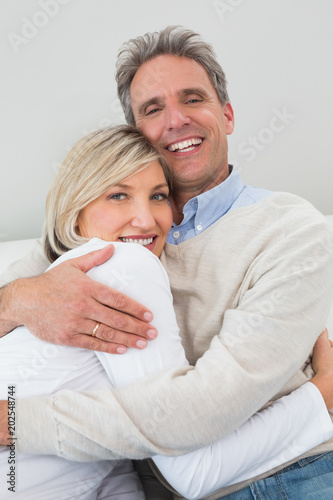 Happy couple embracing at home