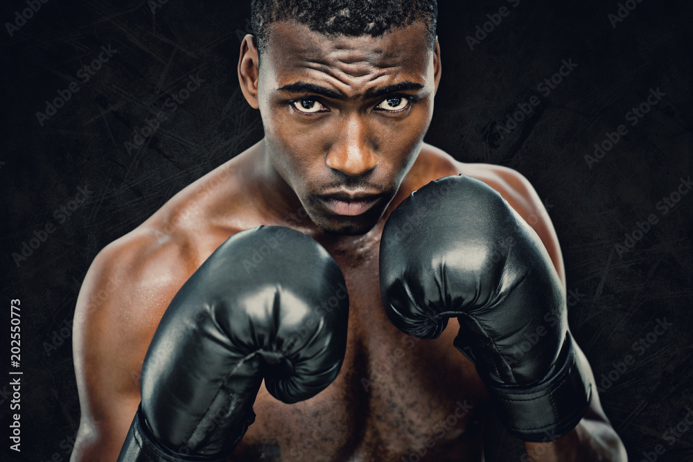 Muscular boxer against dark background