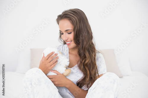 Content attractive brunette holding a soft toy