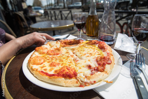 Greasy cheese pizza outside in a cafe patio