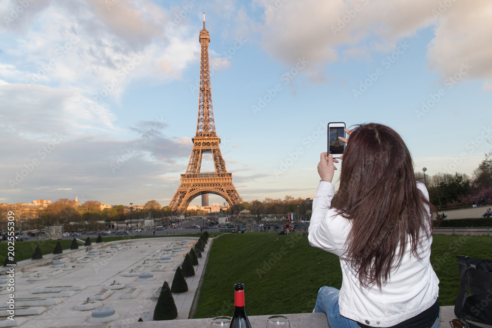 Φωτογραφία Woman taking photo of Eiffel Tower in Paris, France with cellphone