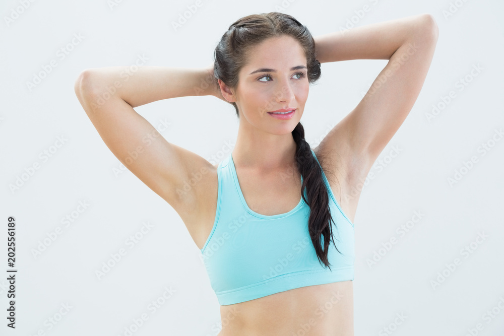 Fit young woman standing with hands behind head Fit young woman standing with hands behind head