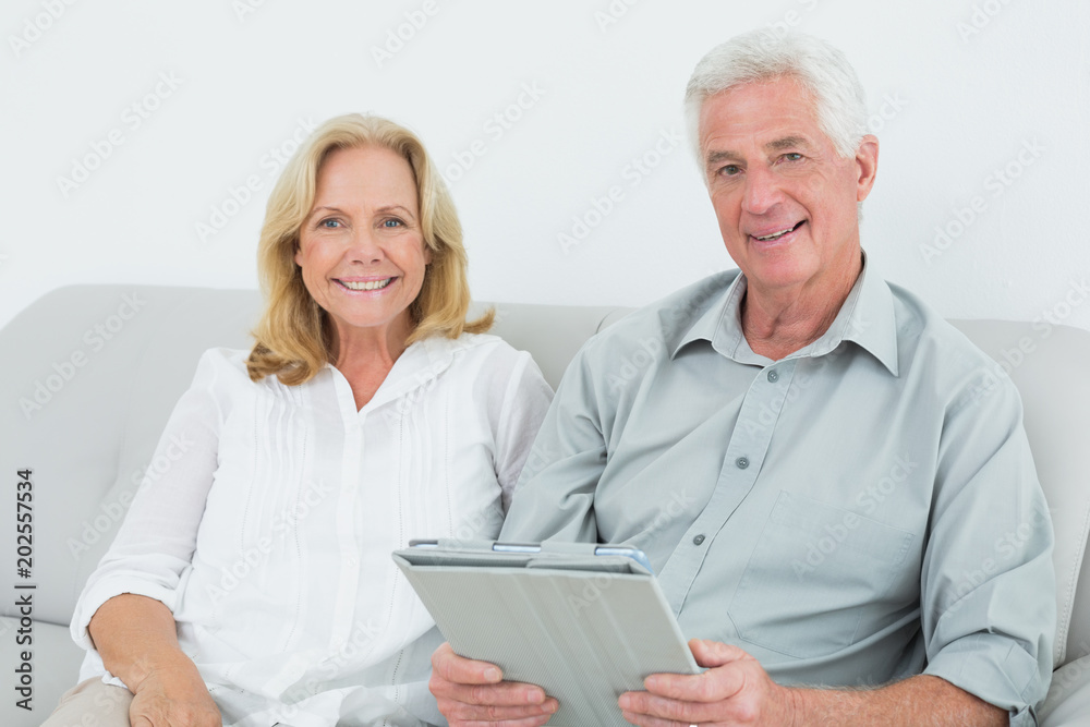 Relaxed senior couple with digital tablet at home