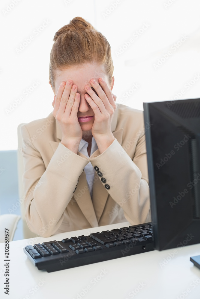 Worried businesswoman covering face at office Worried businesswoman covering face at office