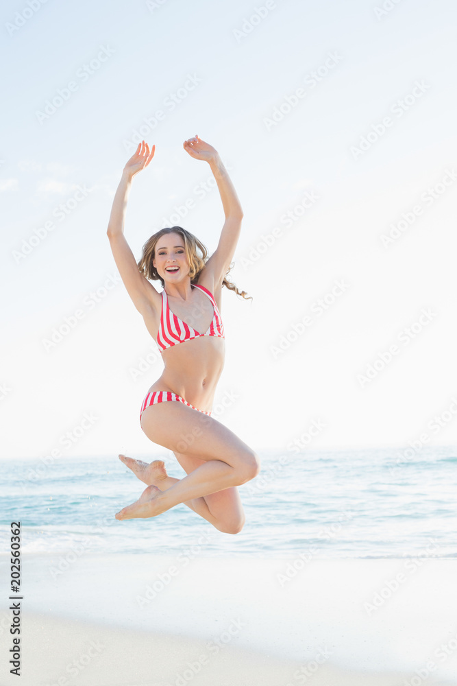 Content young woman jumping on the beach Content young woman jumping on the beach