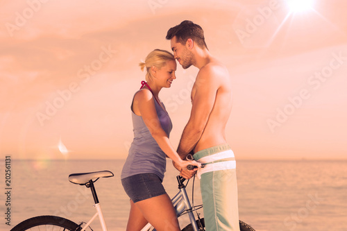 Fototapeta Naklejka Na Ścianę i Meble -  Cute couple together with their bicycles on beach