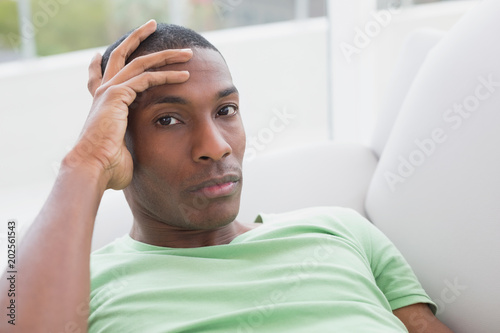 Close up portrait of relaxed Afro man lying on sofa