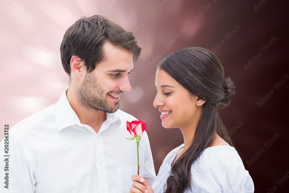Ταπετσαρία Handsome man offering his girlfriend a rose against valentines heart design