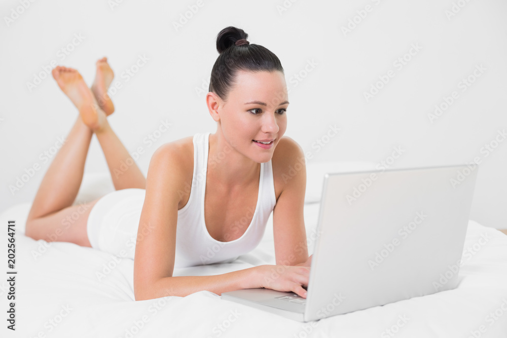 Casual woman using laptop in bed Casual woman using laptop in bed