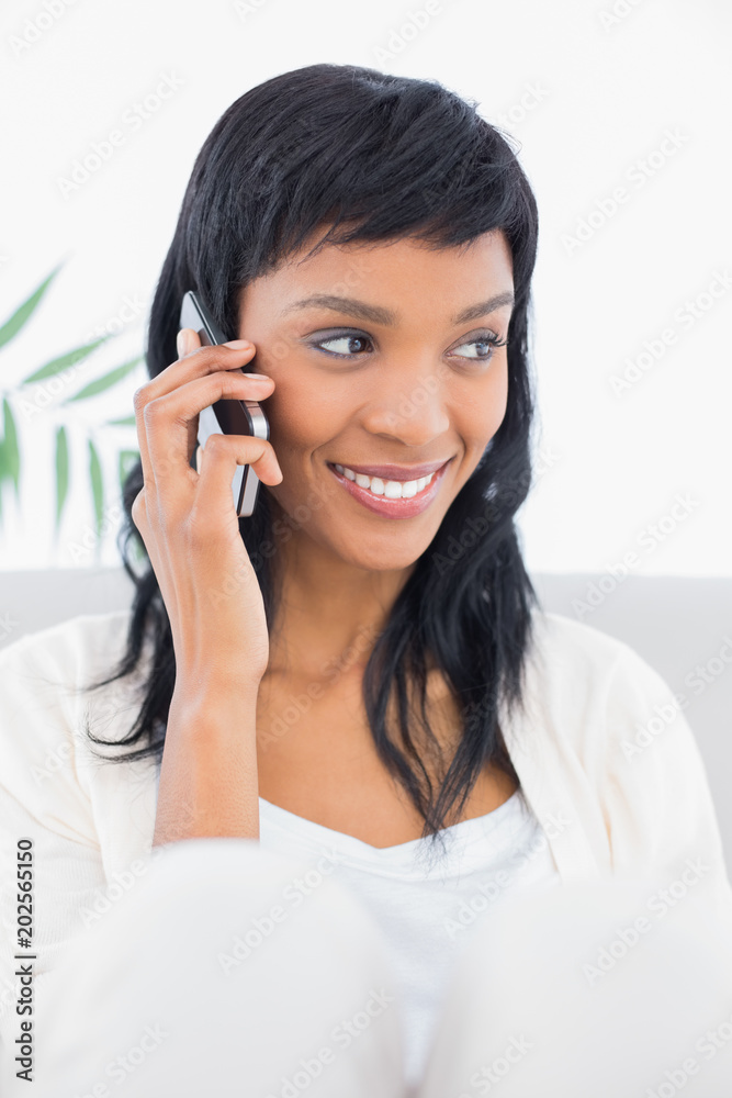 Attentive black haired woman in white clothes calling someone with her mobile phone Attentive black haired woman in white clothes calling someone with her mobile phone