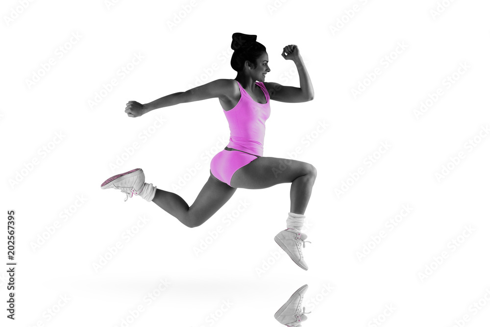 Fit brunette running and jumping against mirror