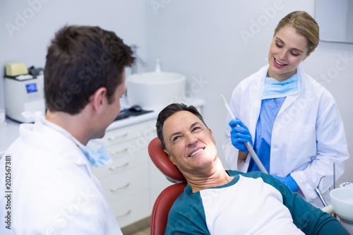 Dentists interacting with a male patient