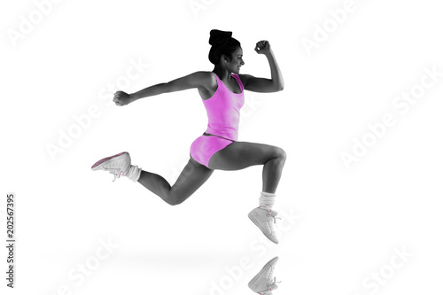 Fit brunette running and jumping against mirror