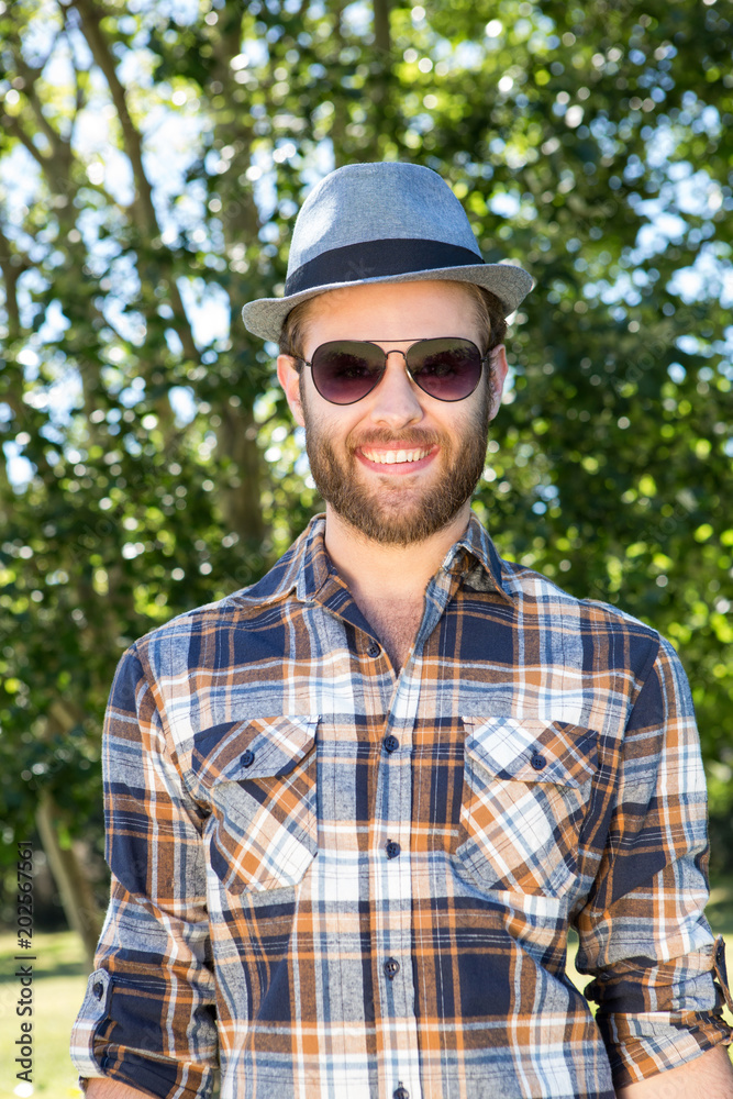 Handsome hipster smiling in the park