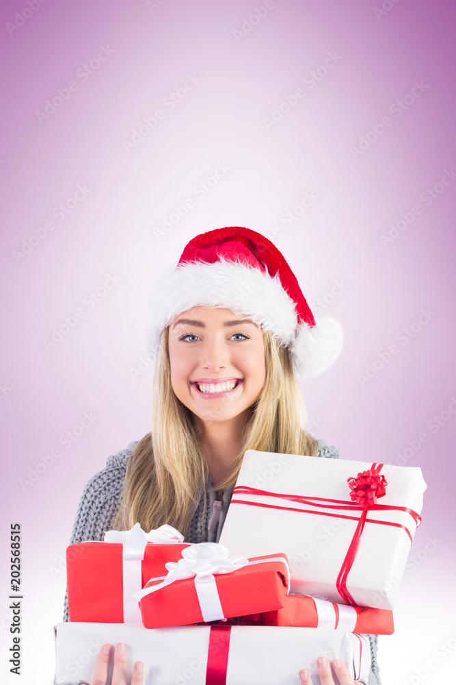 Festive blonde holding pile of gifts on vignette background Festive blonde holding pile of gifts on vignette background