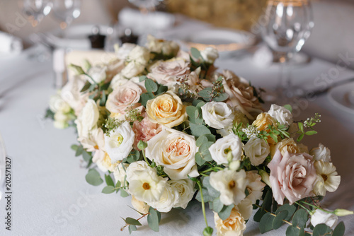 Luxury wedding reception. Flower arrangement on table in restaurant. Stylish decor and adorning.
