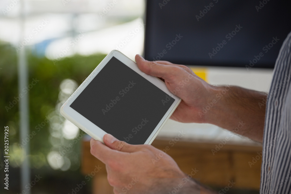 Cropped hands of designer using digital tablet computer
