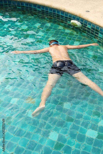 The boy is swimming in the pool