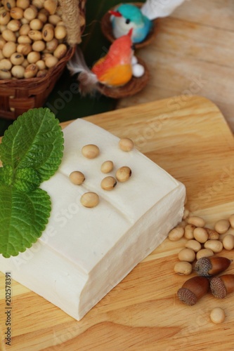 Tofu and soybean seed on wood background