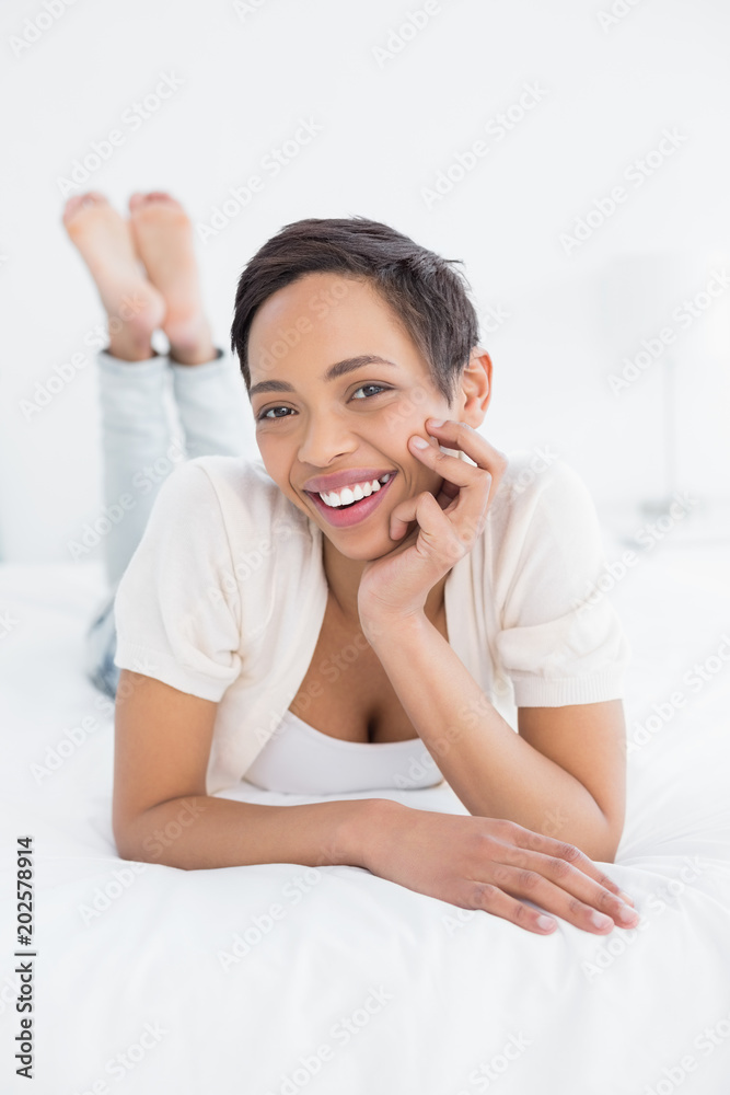 Smiling pretty young woman relaxing in bed