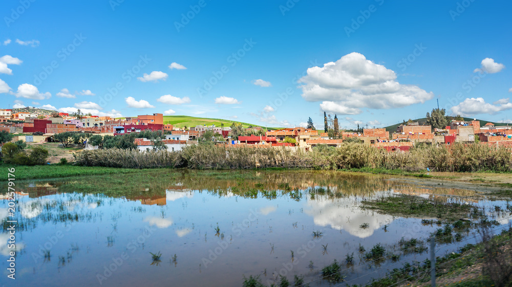 Colorful landscape with beautiful clouds and red buildings in Morocco