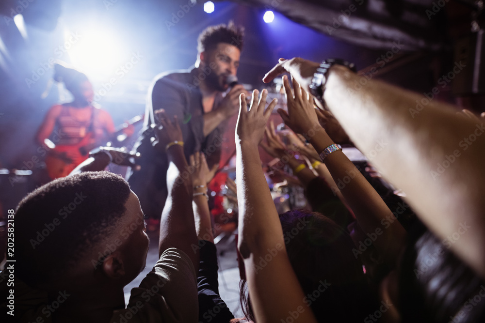 Male singer performing amidst crowd at nightclub