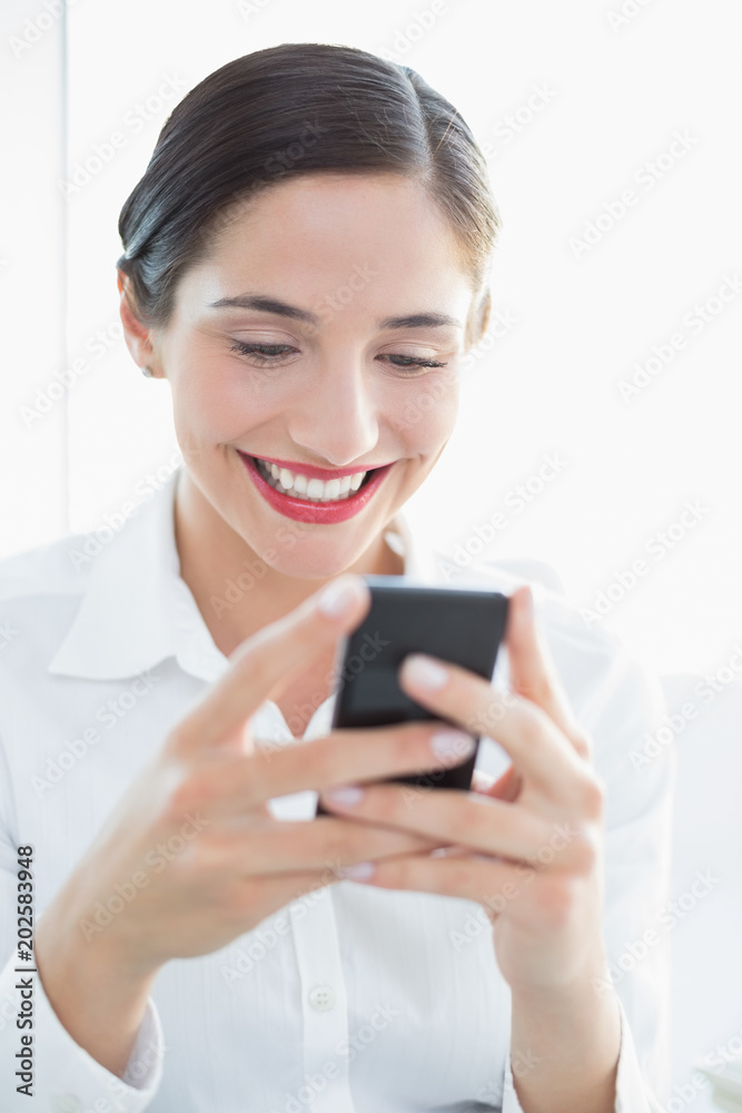 Smiling business woman looking at mobile phone Smiling business woman looking at mobile phone