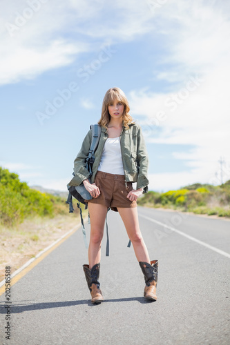 Mysterious sexy blonde posing while hitchhiking