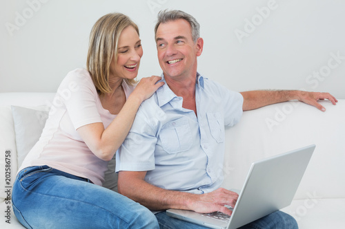 Relaxed couple using laptop at home © WavebreakmediaMicro