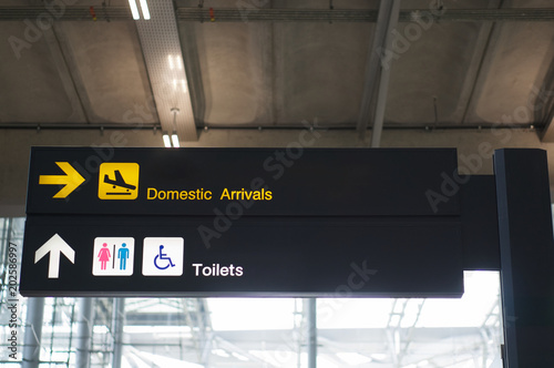 Domestic arrivals and toilets board sign at international airport