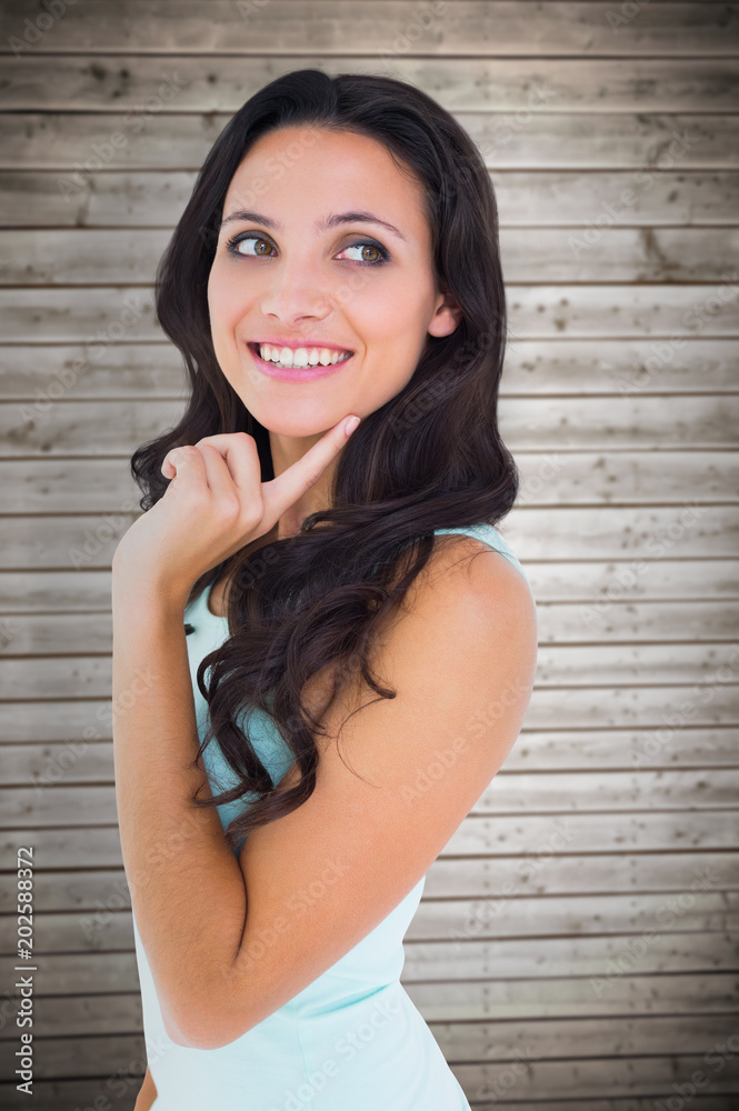 Pretty brunette getting an idea against wooden planks background Pretty brunette getting an idea against wooden planks background