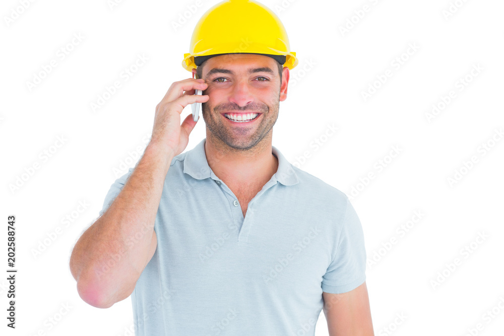Smiling handyman talking on mobile phone