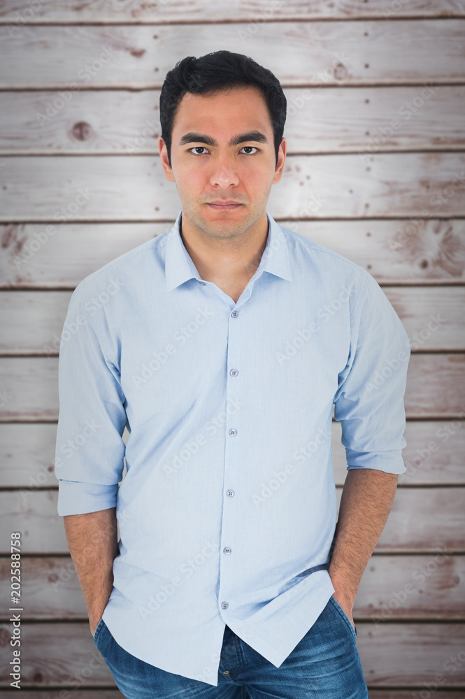 Obraz premium Unsmiling casual man standing against wooden planks