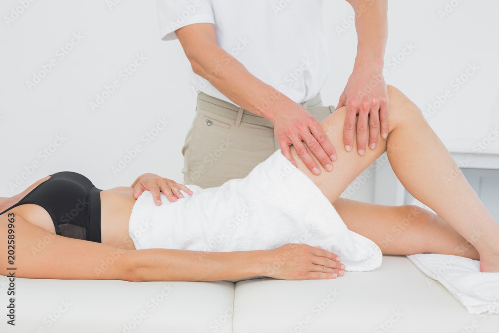 Fototapeta premium Fizjoterapeuta badający nogę młodej kobiety