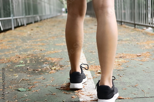 Woman's legs running exercise outdoors. Fitness and wellness concept.
