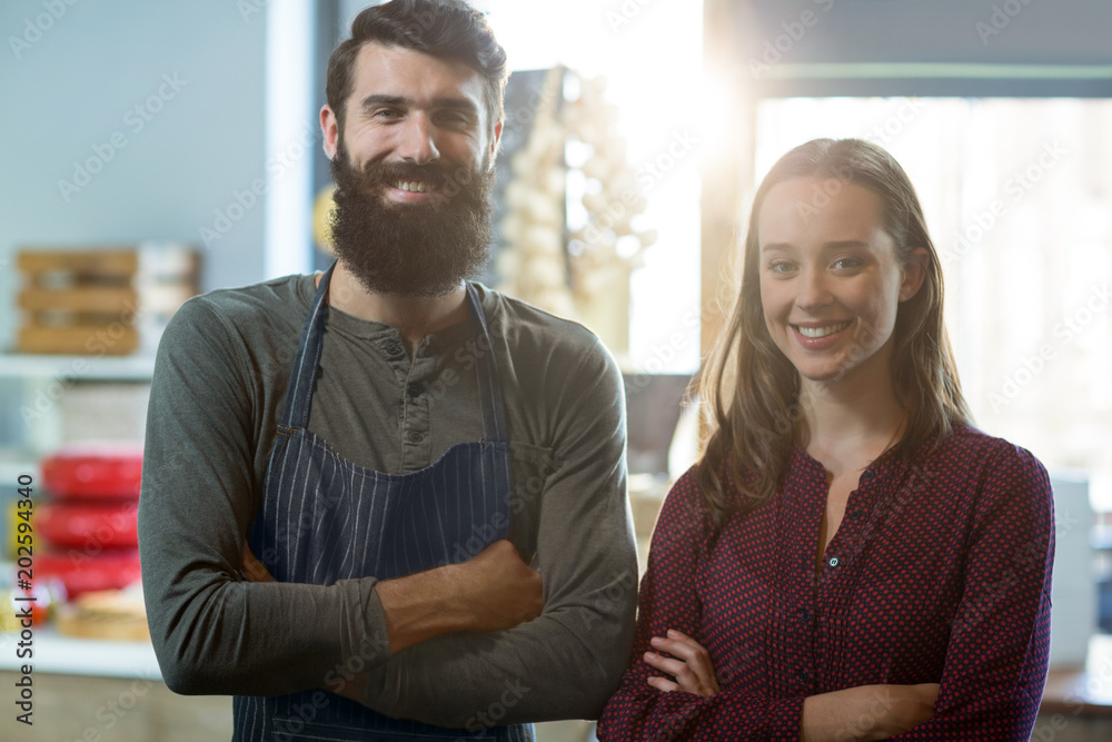 Portrait of smiling bakery staff standing with arms crossed Portrait of smiling bakery staff standing with arms crossed