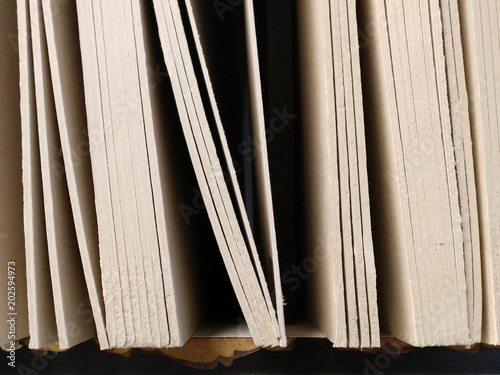 thick hard stiff paper board lined up in shelf, making slope line pattern