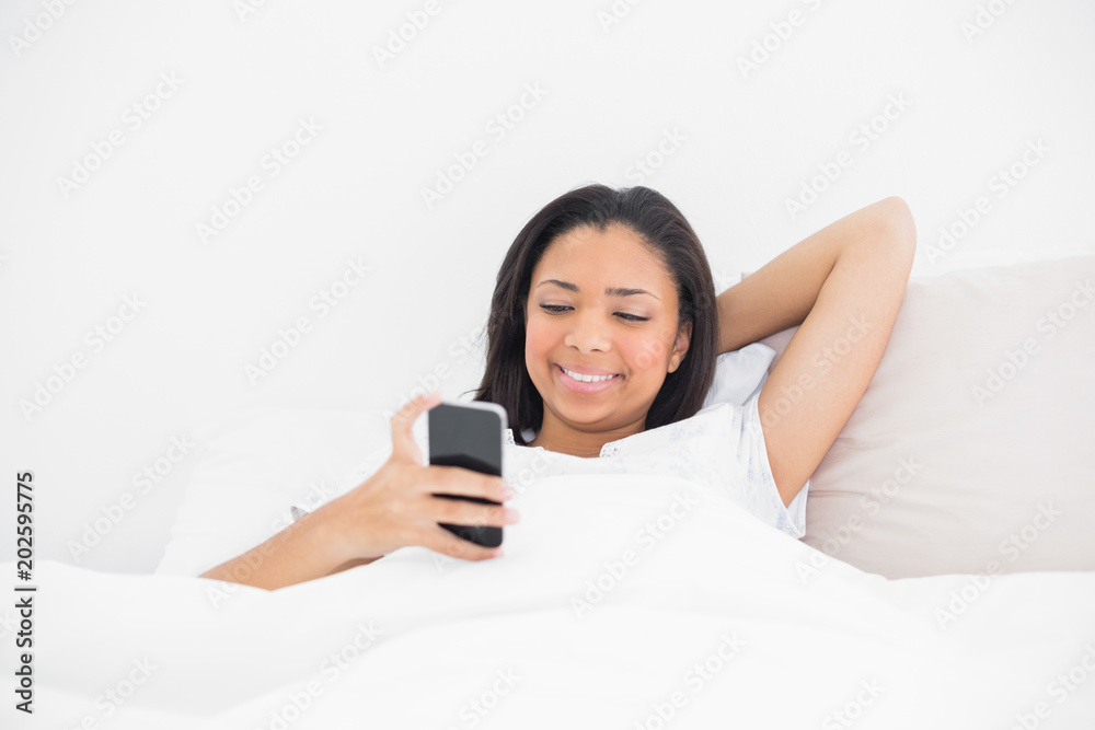 Relaxed young dark haired model using a mobile phone Relaxed young dark haired model using a mobile phone