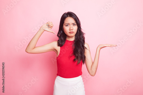 Young Asian woman show palm hand and thumbs down.