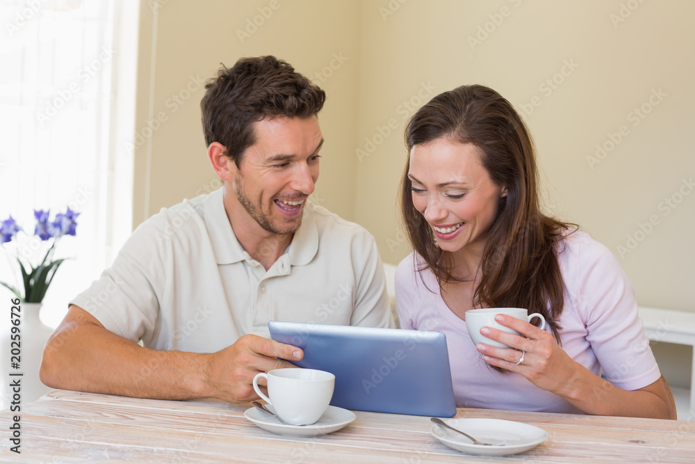Couple using digital tablet while having coffee Couple using digital tablet while having coffee